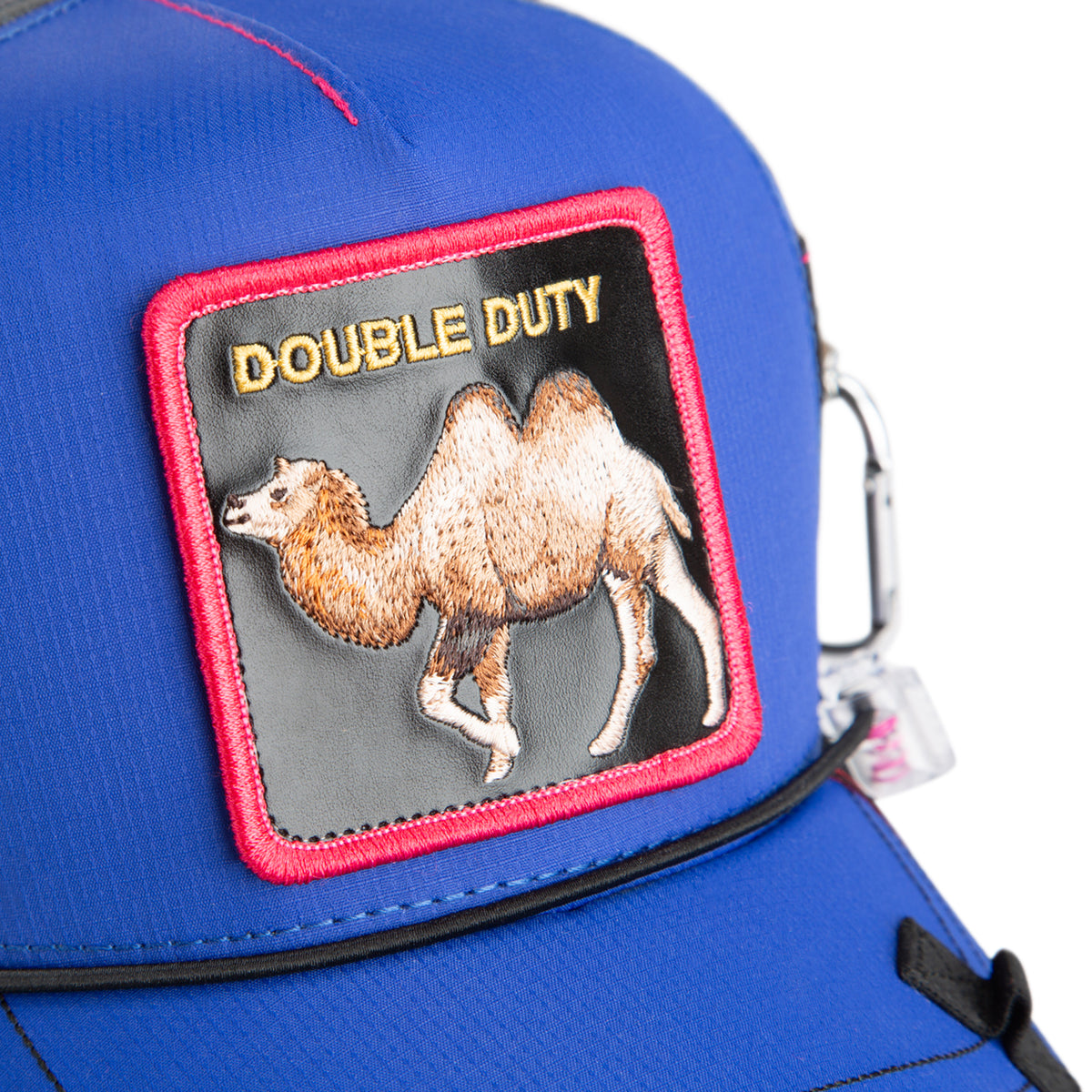 A blue, water-resistant hat from The Farm called “Oversized Package,” featuring a red-bordered patch with a camel and the words DOUBLE DUTY embroidered at the top.