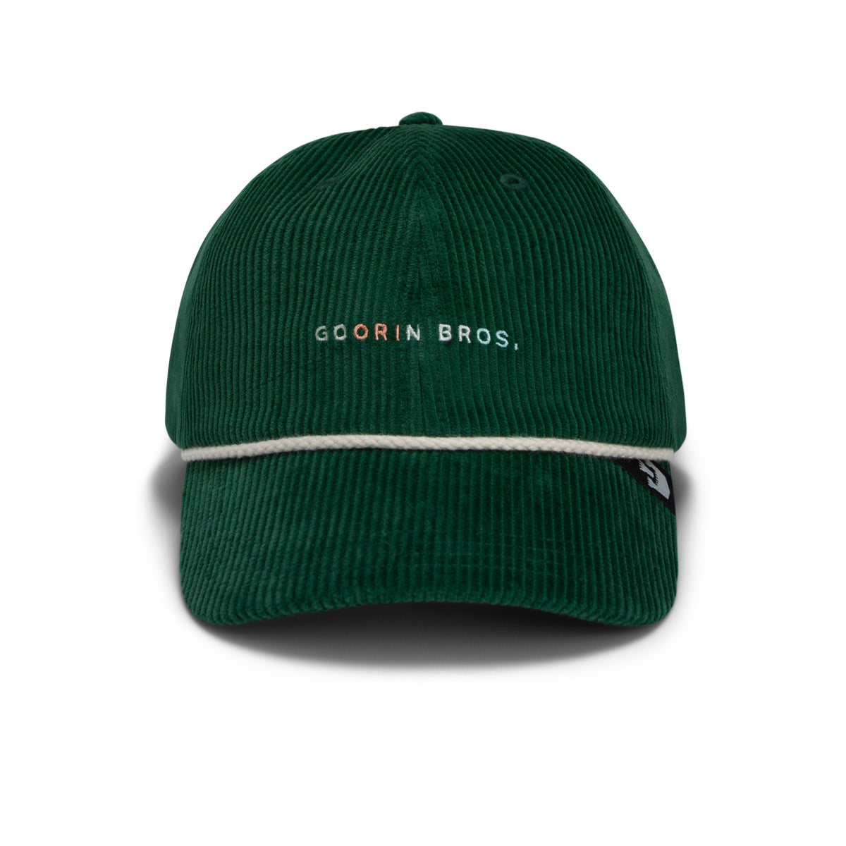 Introducing The Clubhouse by Goorin Bros.: a dark green wide wale corduroy baseball cap, featuring a white rope across the brim and “GOORIN BROS.” elegantly embroidered on the front, exuding quiet luxury in every detail.