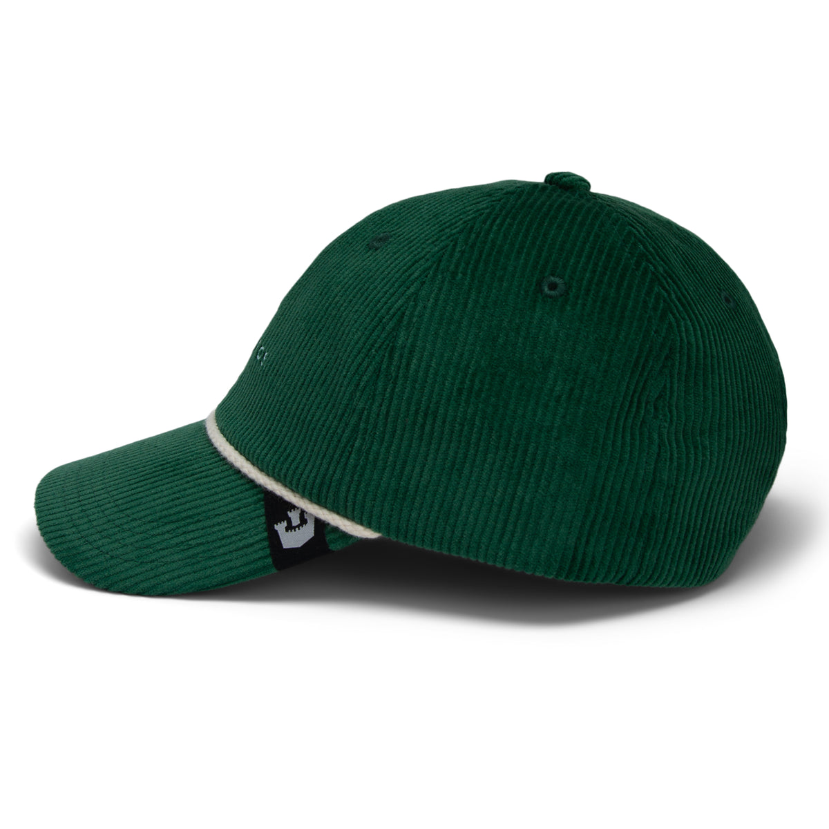 The Clubhouse by Goorin Bros. is a dark green wide wale corduroy baseball cap featuring a curved brim and white trim along the edge, shown from a side angle for an understated touch of quiet luxury.