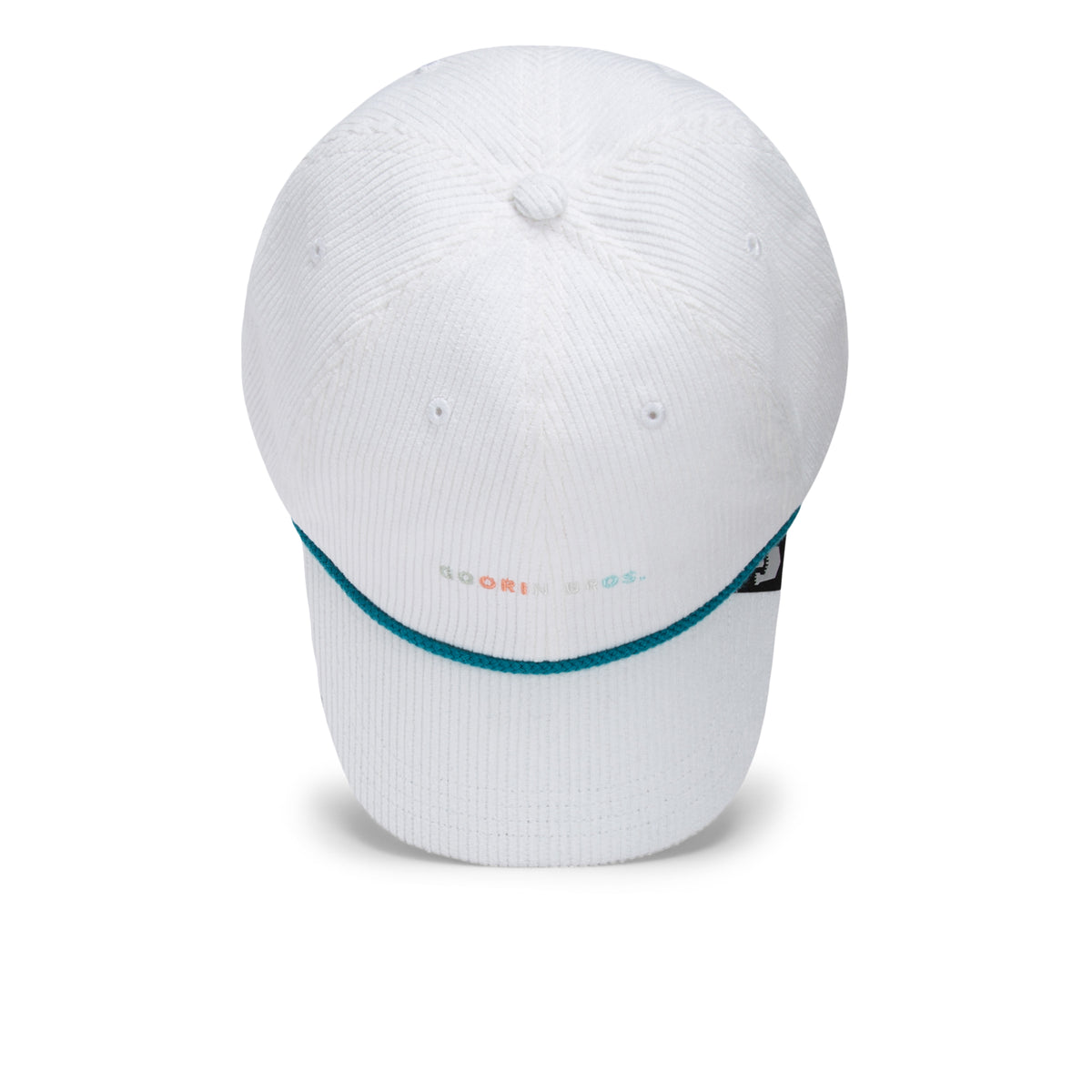 The Clubhouse by Goorin Bros. is a white baseball cap with a curved brim, accented with blue trim and small multicolored text on the front, embodying quiet luxury. Crafted from wide wale corduroy for a unique texture and featuring a black side tag, this cap is displayed against a plain white background.