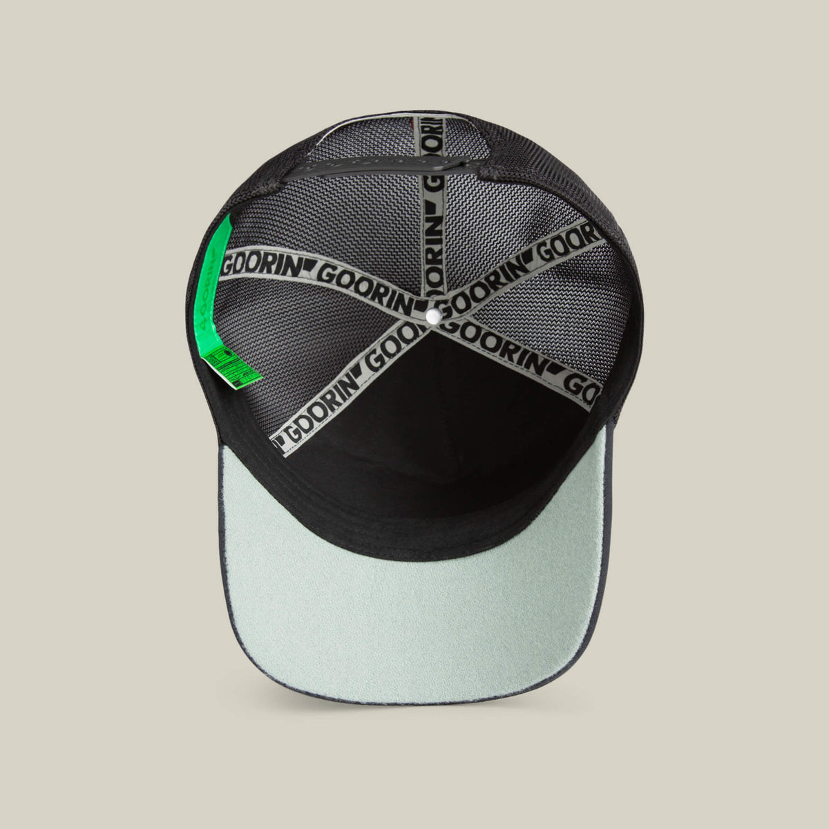A top-down view of the inside of the Means Understood cap by Goorin Bros. in black and light gray highlights quality details like Goorin branding on the seams and a green tag. Please note all sales are final.