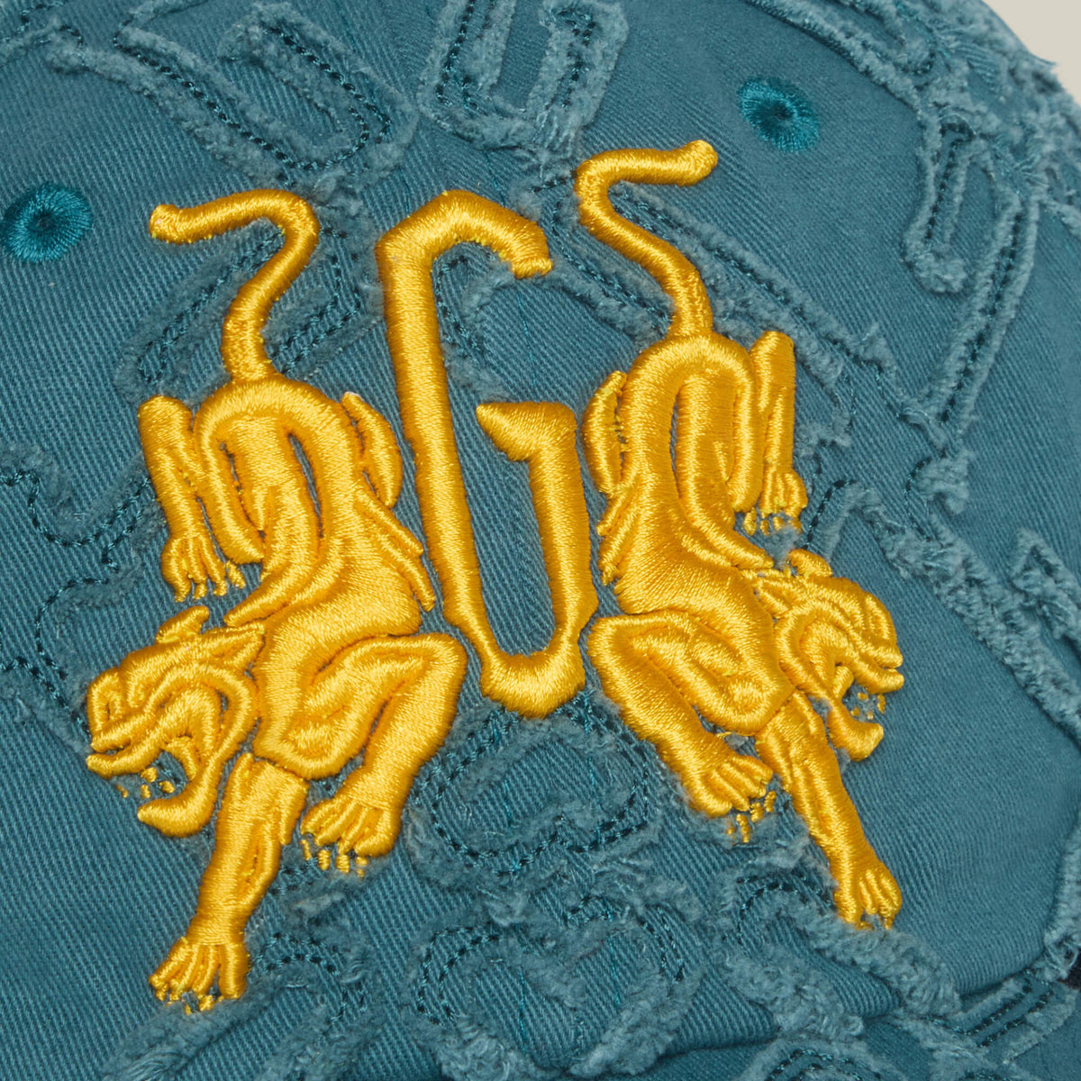 The Future Baby Daddy cap by Goorin Bros. features teal fabric with yellow embroidery of two mirrored tigers encircling a bold G, while textured stitching adds standout detail and main character energy.