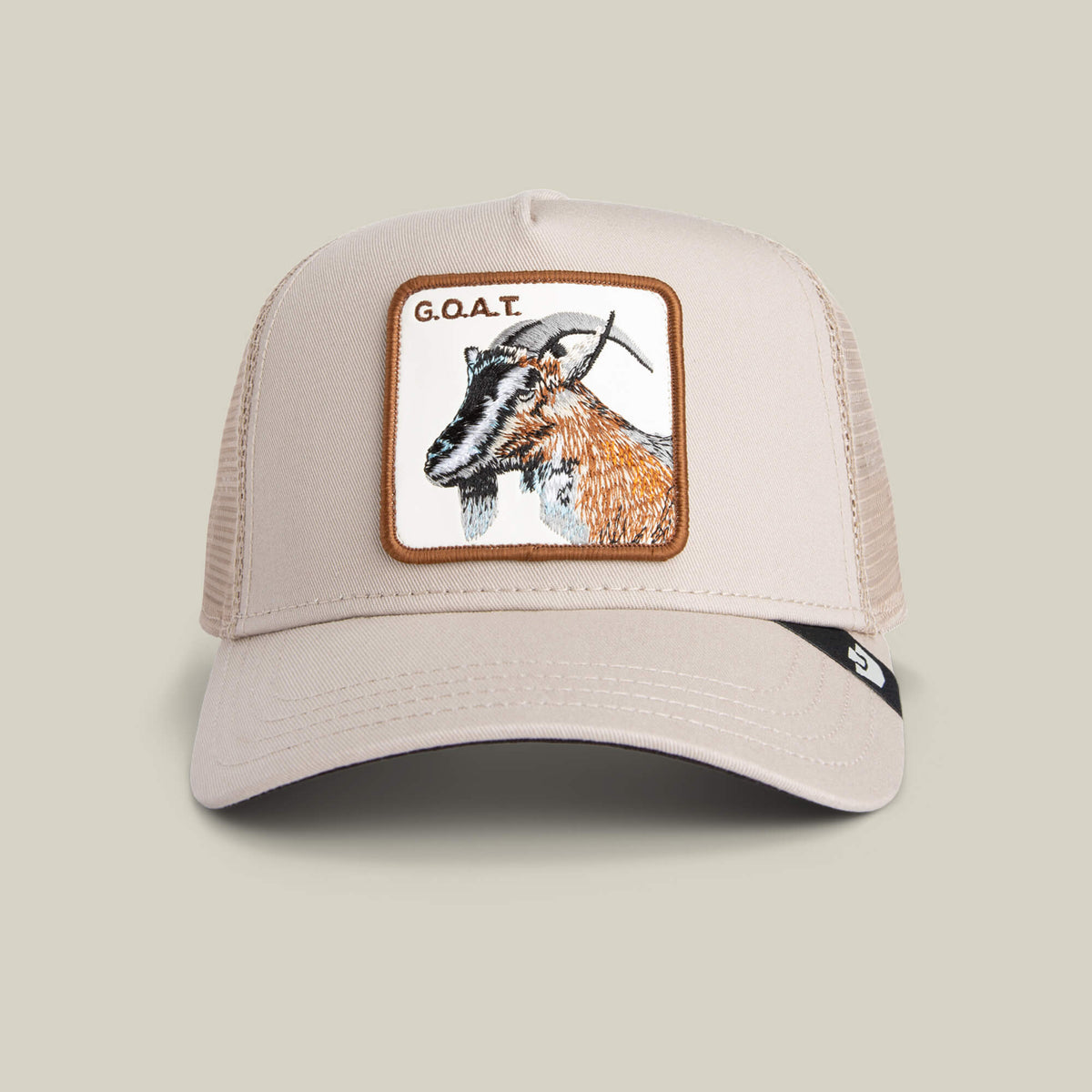 The Goorin Bros. Goat Trucker hat in BISCUIT features neutral tones, a mesh back, and a bold goat head patch with "G.O.A.T." embroidered above.