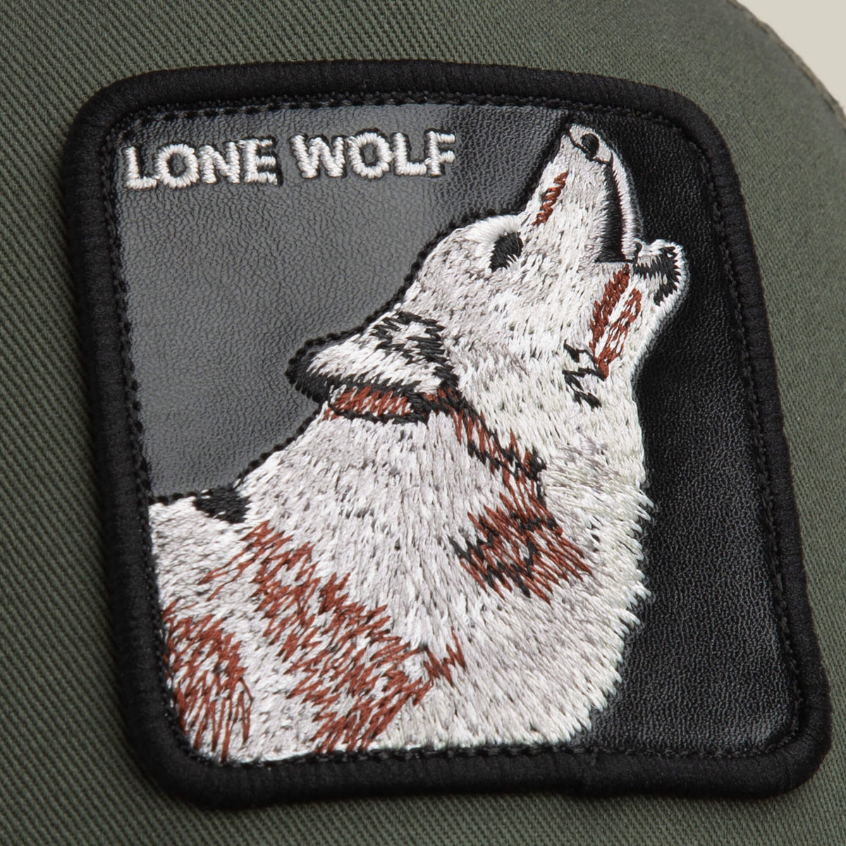The Lone Wolf Trucker by Goorin Bros. features an embroidered howling wolf and "LONE WOLF" text on an olive green trucker-style cap, channeling bold outlaw energy.