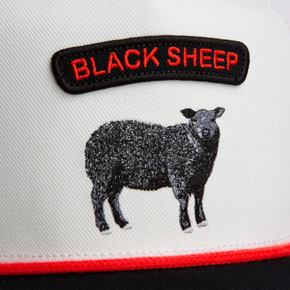 A close-up of the Goorin Bros. Pop Rocker Sheep trucker cap shows an embroidered black sheep with a bold red Pop Rocker Sheep patch above it.