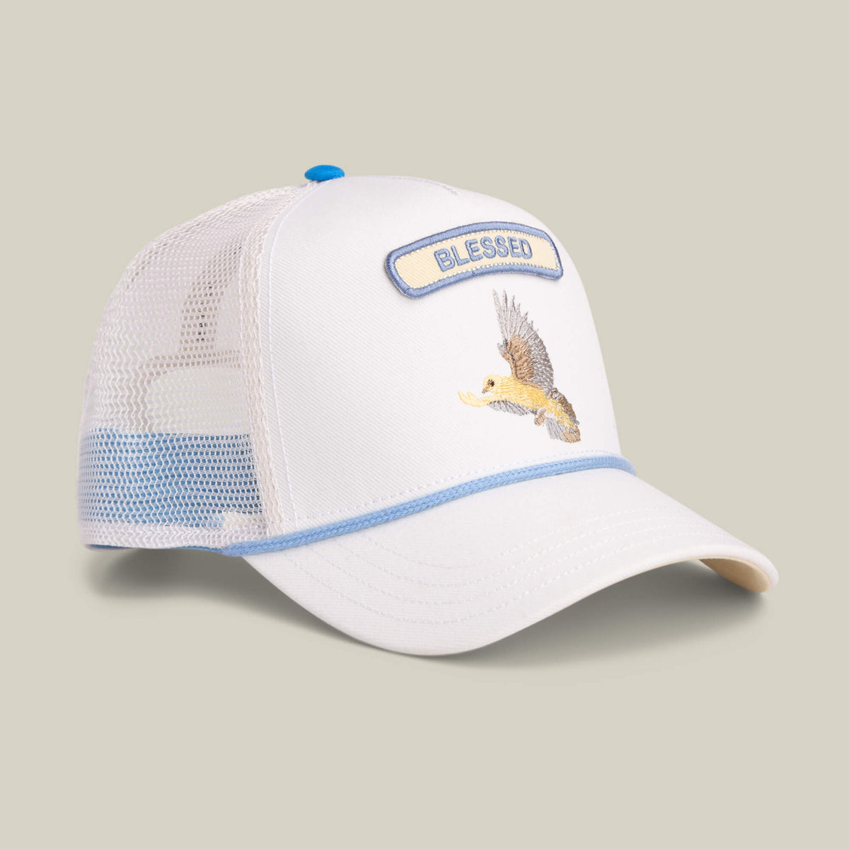 The Goorin Bros. Pop Rocker Blessed trucker hat features a white mesh back, blue trim, an eagle carrying a fish, and an embroidered BLESSED patch—perfect for adding a bold, meaningful touch to your casual style.