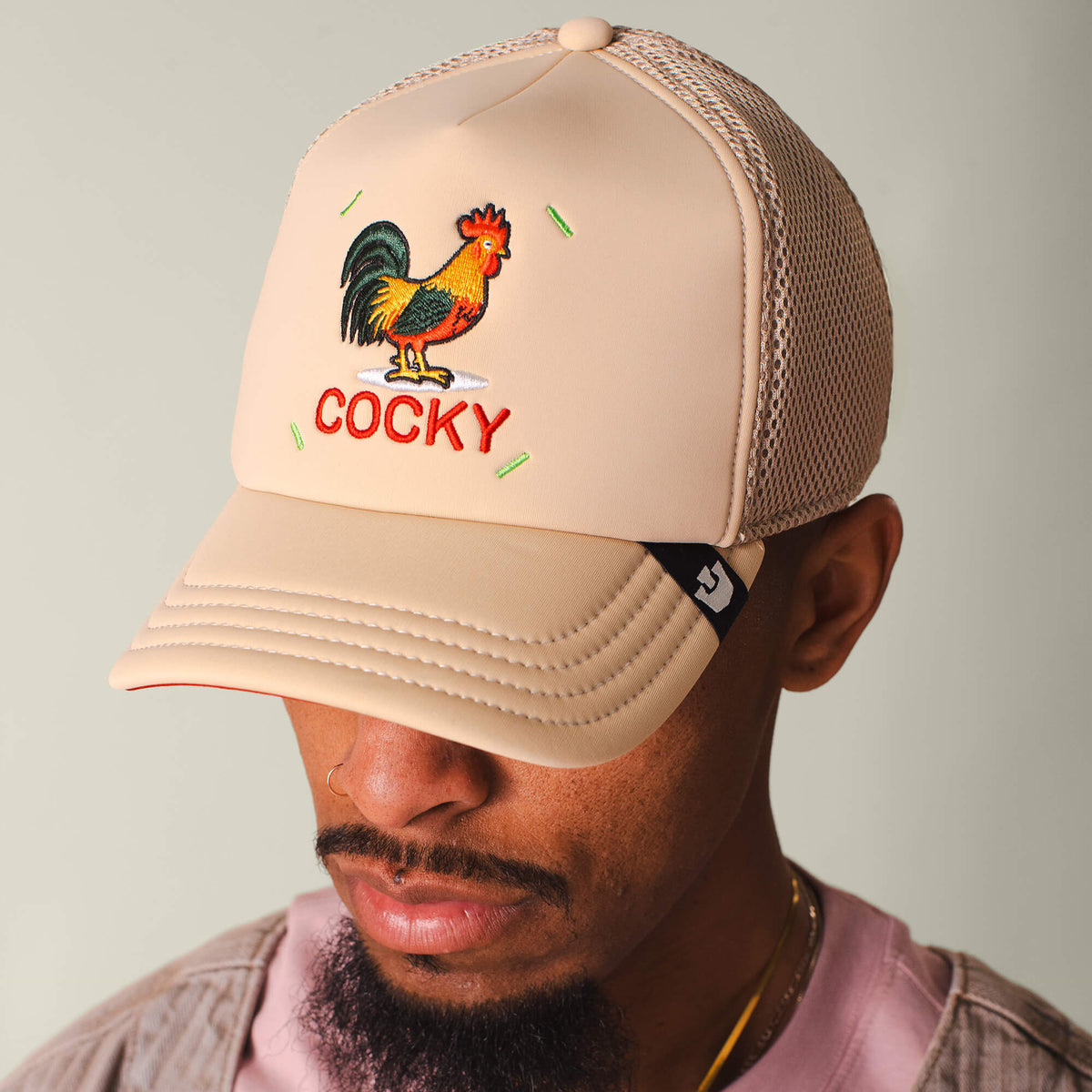 Wearing the Goorin Bros. Neo Farm - Cocky Rooster hat and a pink cocky shirt creates a playful neutral lookβideal for those who love standout farm-inspired style.
