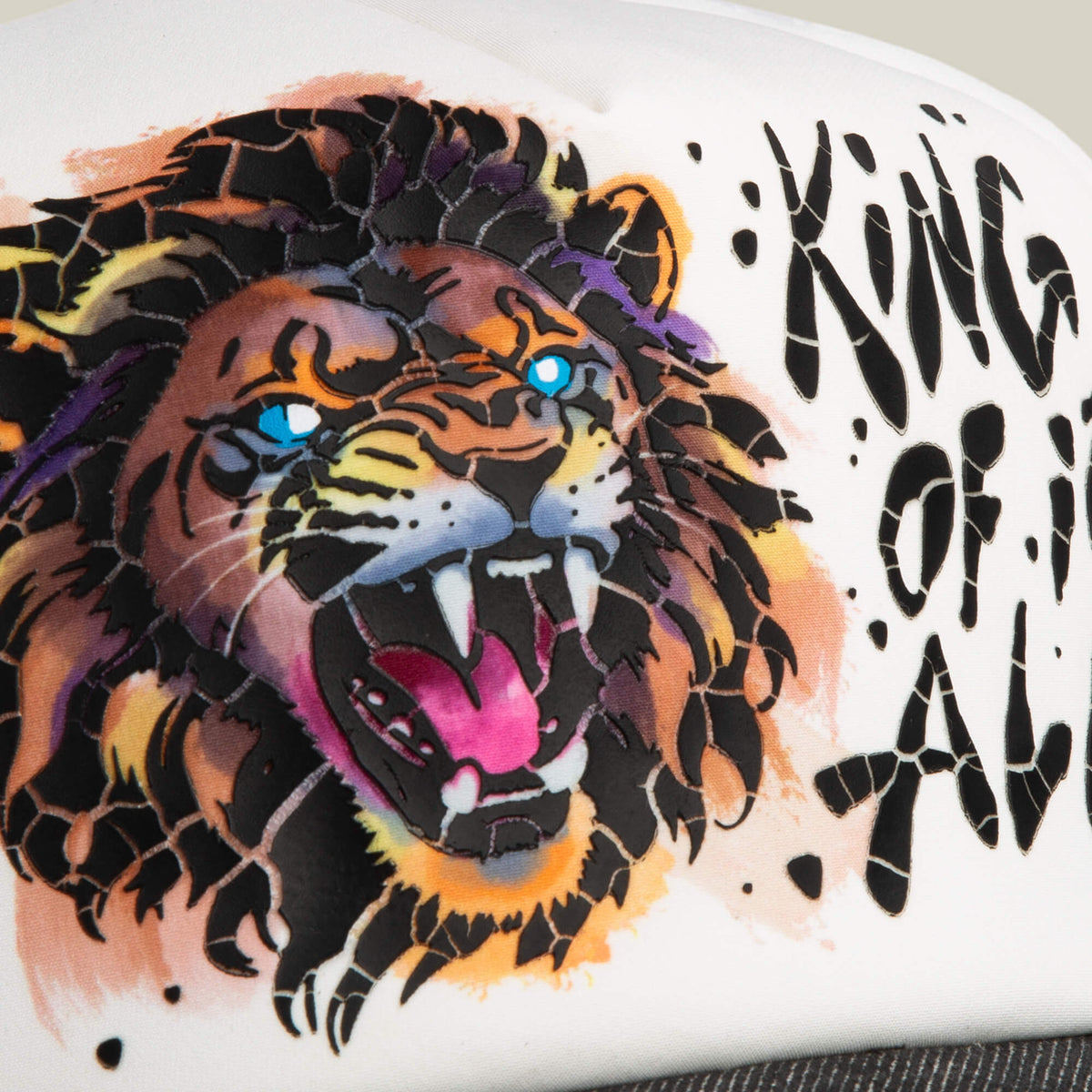 Illustration of a roaring lion with blue eyes and bared teeth beside the text King Disruption, inspired by the iconic Goorin Bros. King Disruption cap, on a white background.