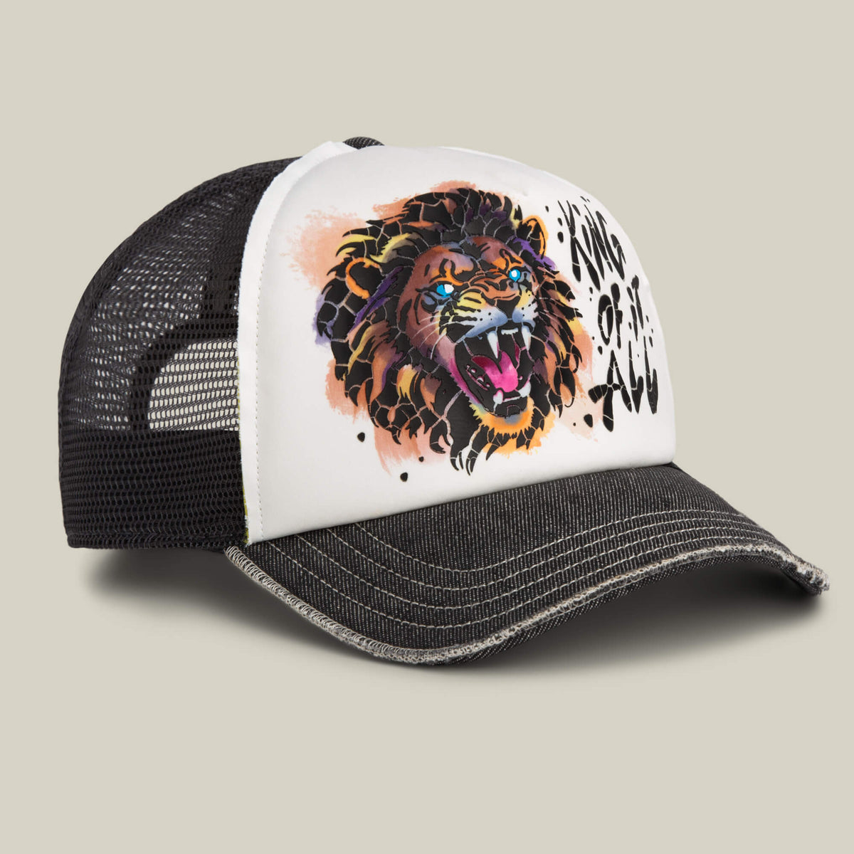 A black mesh trucker hat with a white front panel featuring a vibrant roaring lion and "KING OF ALL" text—Goorin Bros.' King Disruption cap inspired by their classic style.