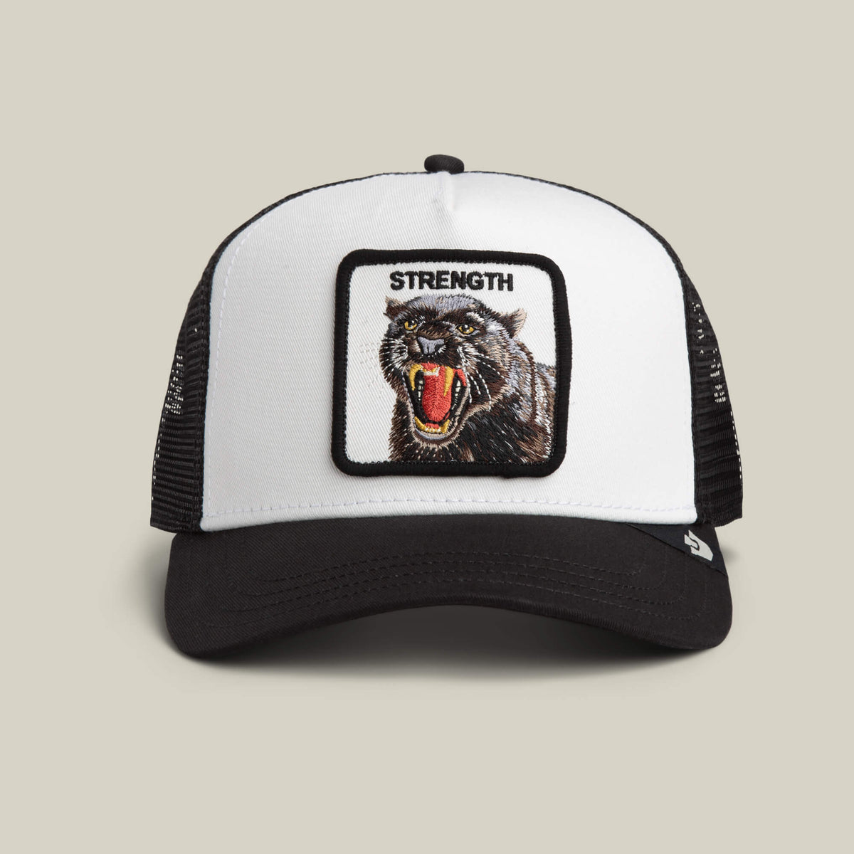 The Strength Panther Trucker by Goorin Bros. in DUST / VOID features a bold embroidered "STRENGTH" above a dynamic panther patch on this stylish black and white cap.