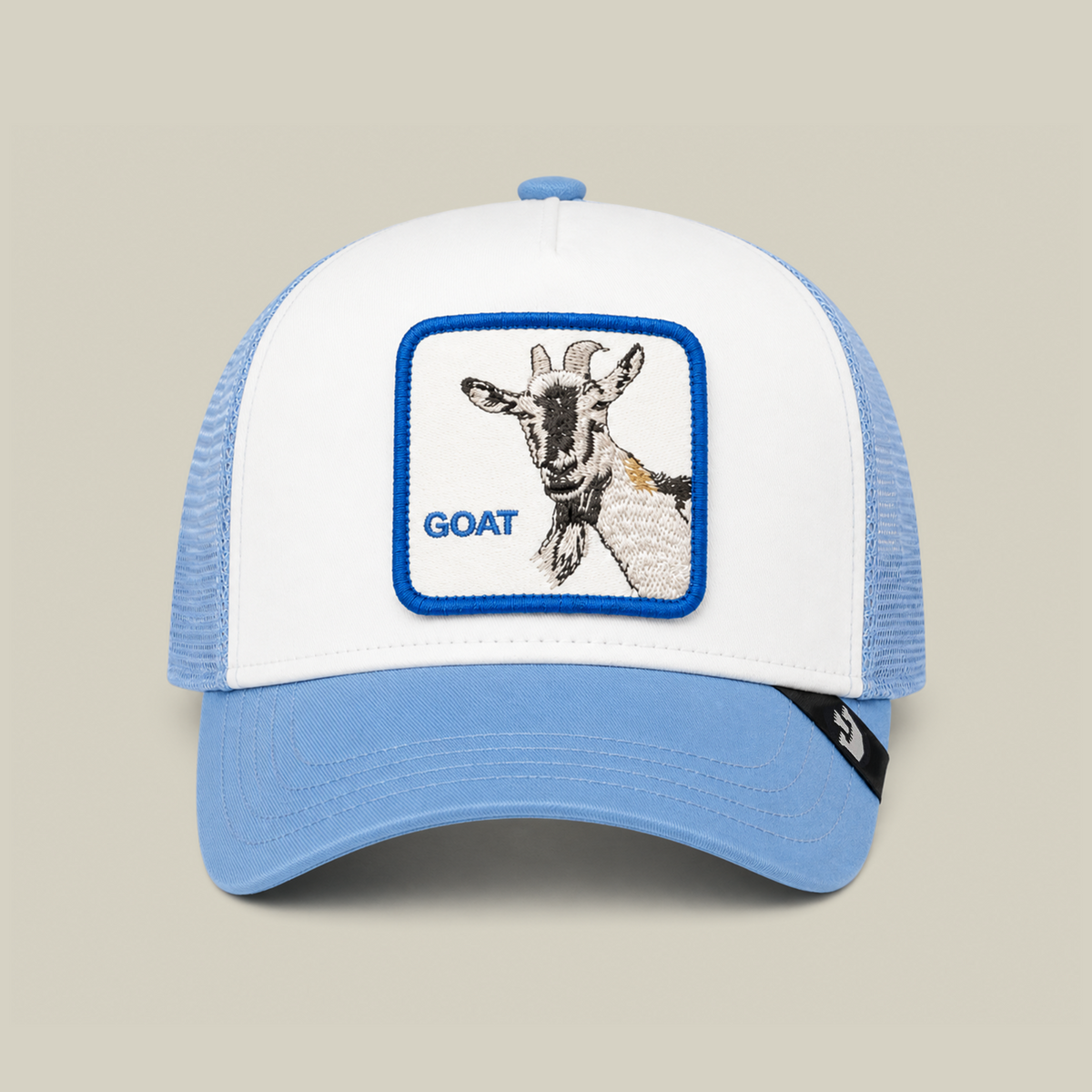 A white and light blue Goorin Bros. La Pulga Atomica trucker hat featuring an embroidered goat’s head patch and the word GOAT on the front.