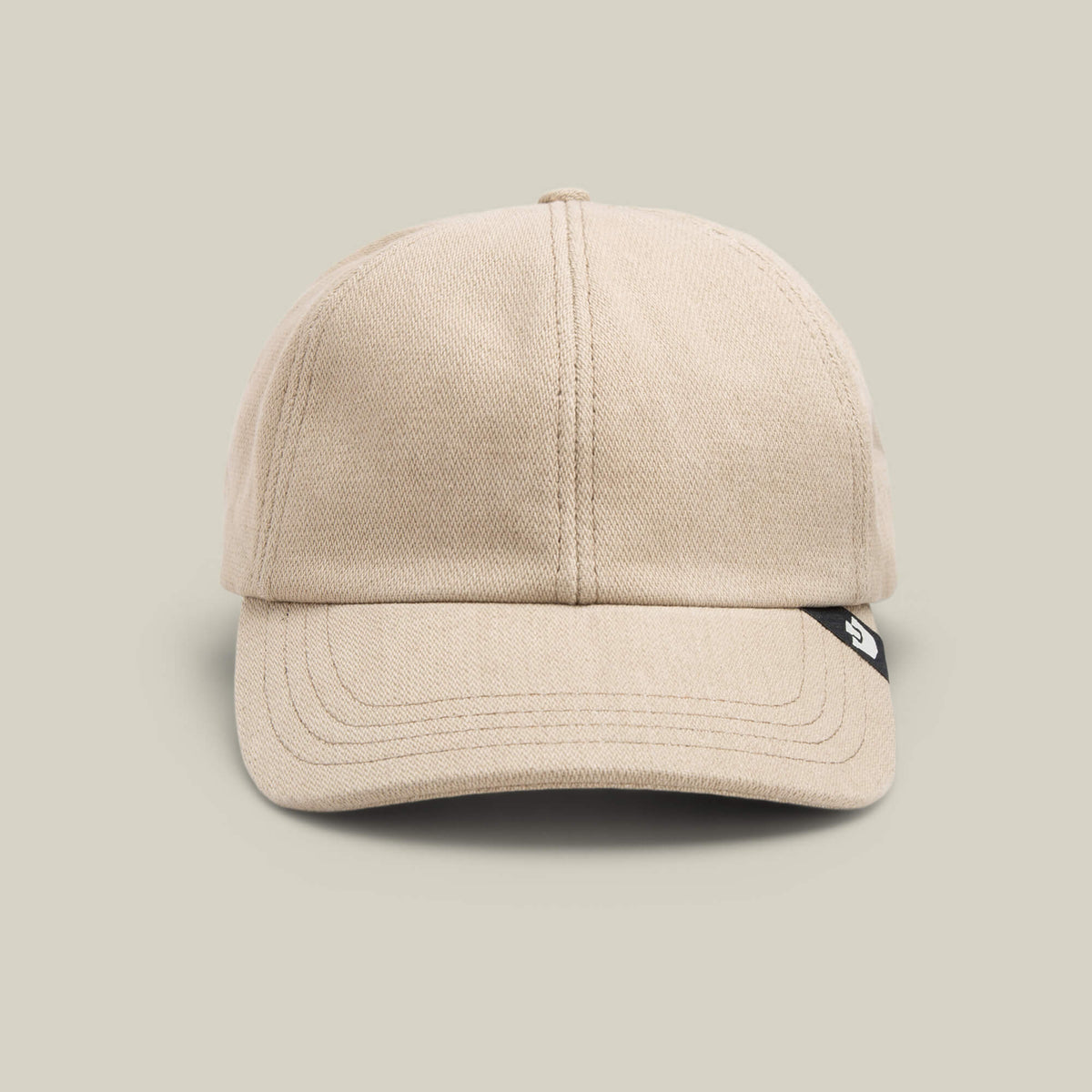 The Noisy Tailored Baseball cap by Goorin Bros. in BISCUIT features visible stitching, a black tag on the right brim, and a front-facing design—perfect for those who value subtle confidence and color-driven style.