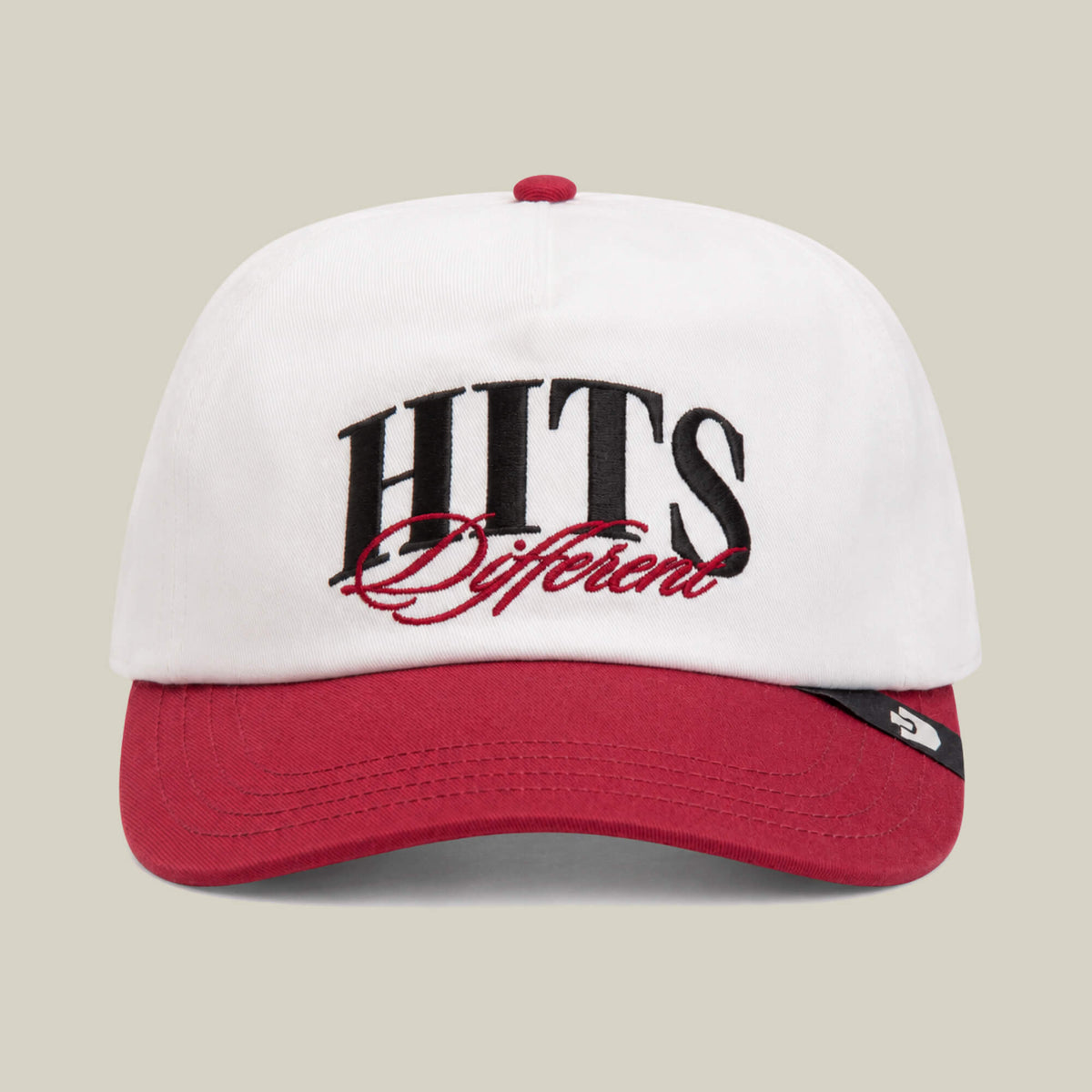 The Goorin Bros. Hits Different cap in Dust/Crush features a red curved brim and bold front embroidery of "HITS Different.