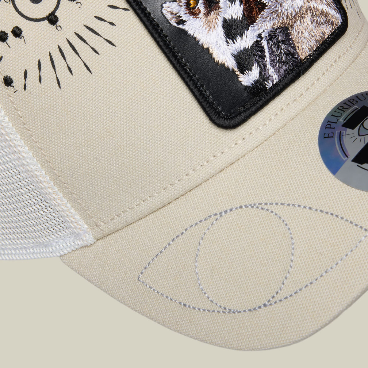 The Goorin Bros. G-Anon baseball cap in cream and black features embroidered cat designs on the front and back panels, shown in a flat lay product shot highlighting its structured silhouette and detailed stitching.