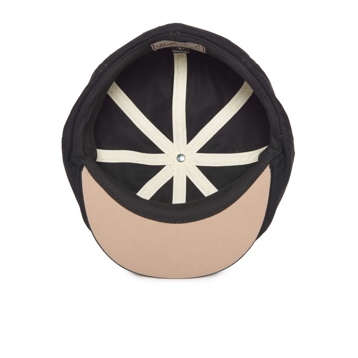 The Mulberry Street by Goorin Bros. is a beige and black baseball cap, shown from above to reveal its interior white panel seams and beige brim—a stylish choice reminiscent of a trendy flatcap for those who appreciate classic headwear with a modern twist.