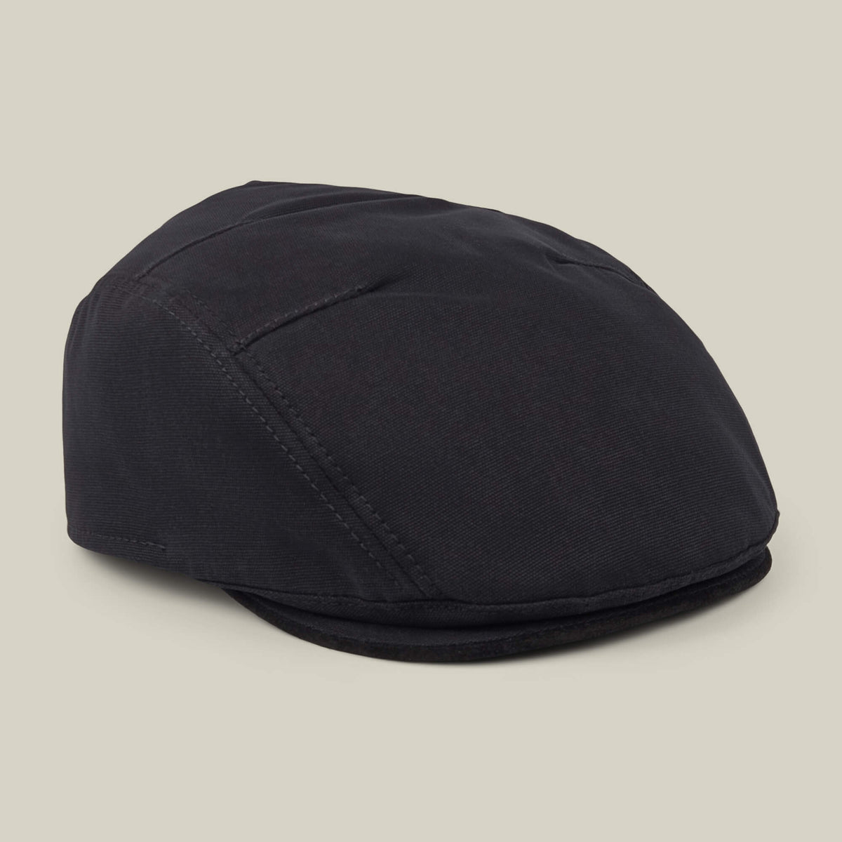 The Heatherwood flatcap by Goorin Bros., crafted from black cotton suede in the USA, is shown against a plain beige background.