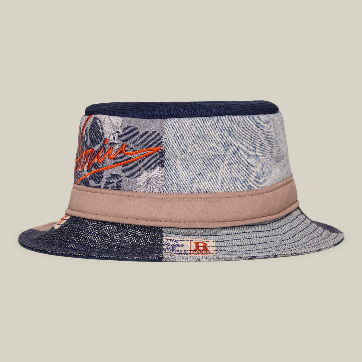 The Goorin Bros. Goorin Rework Bucket is a patchwork bucket hat with denim, floral, and striped patterns, tan accents, and red embroidered text, made in the USA.