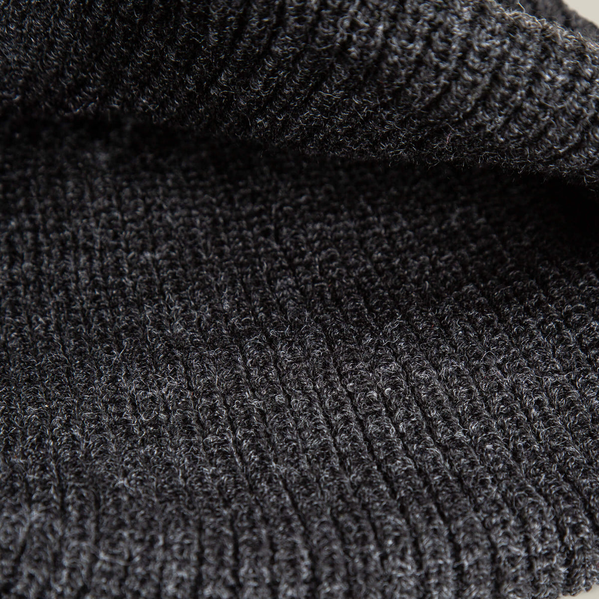 Close-up of the dark gray, ribbed knit fabric of The Panther Beanie by Goorin Bros., showcasing its soft texture and visible horizontal ridges—perfect for a warm, stylish beanie.