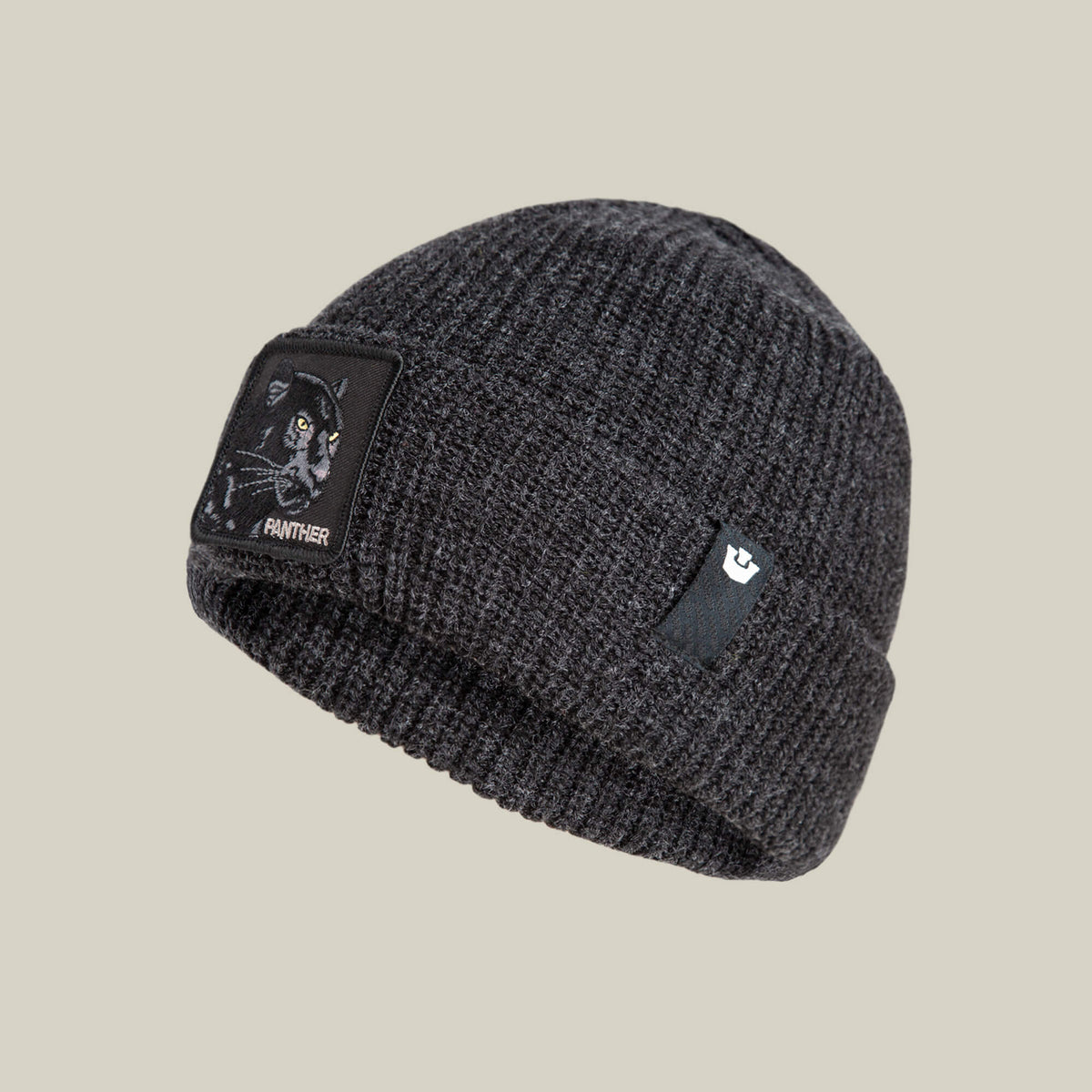 The Panther Beanie by Goorin Bros. is a dark gray beanie featuring a bold panther illustration and text on the front, plus a small black tag with a white logo on the side for added style and warmth.