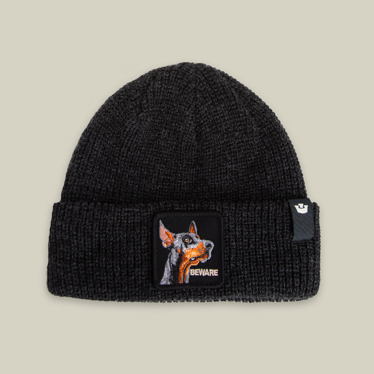 The Beware Beanie by Goorin Bros. in VOID features a heavyweight knit and a front cuff patch with a dog's face and "BEWARE"—ideal for those seeking a bold, guard dog-inspired accessory.
