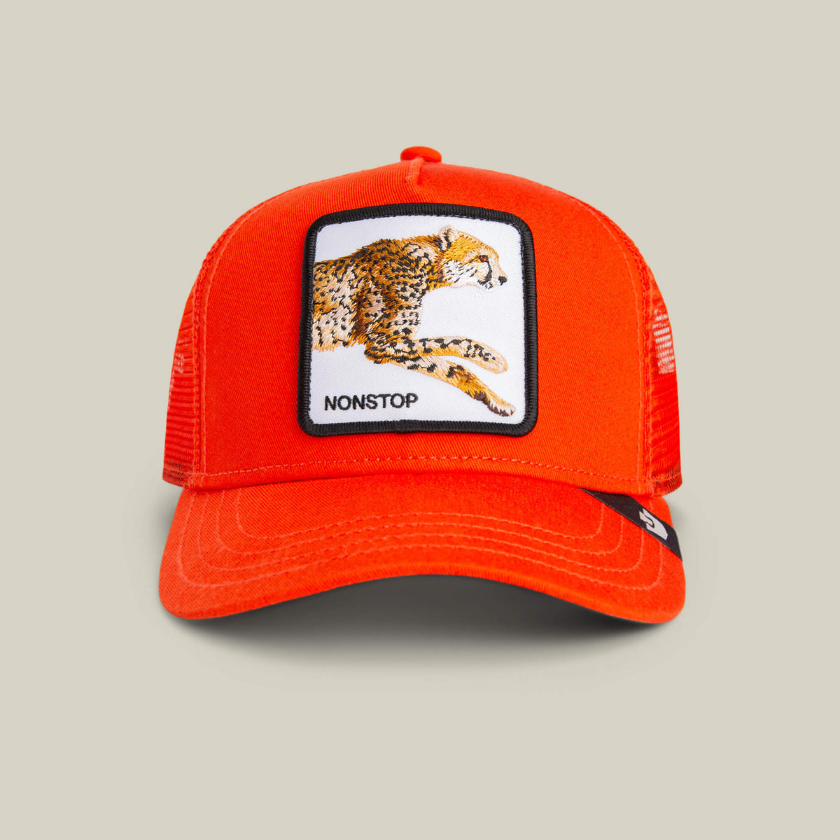 The Goorin Bros. The Nonstop Cheetah Mini Noir kids cap in BLAZE features a bright orange mesh design with an orange crown and a front patch displaying an embroidered cheetah and the word “NONSTOP” in black text.