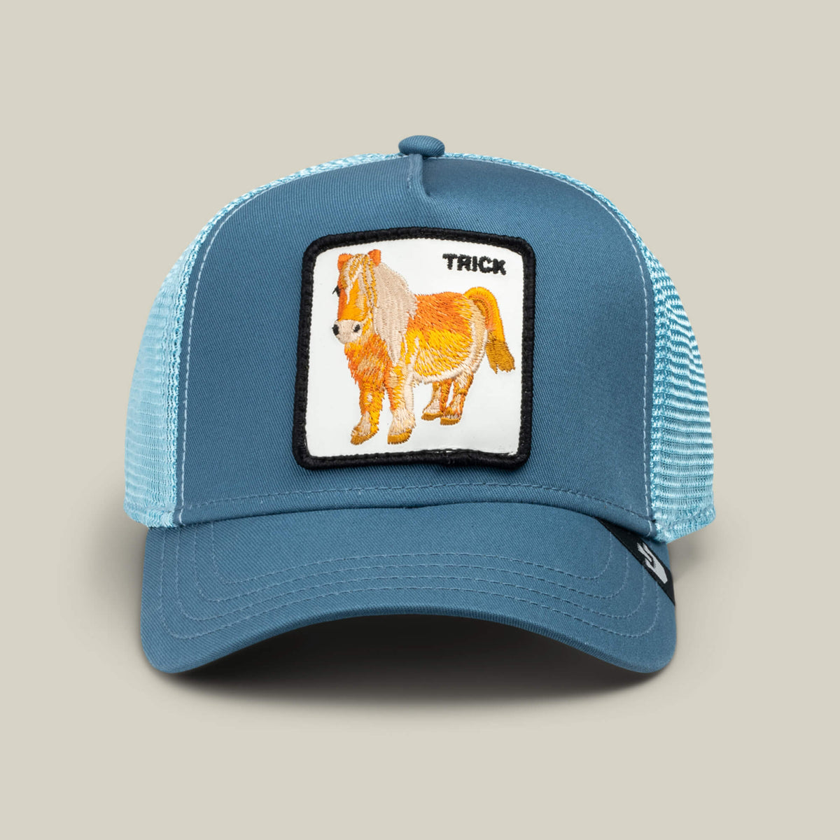The Goorin Bros. "Dad and Pony Show (Kids)" hat features an air blue mesh trucker design with a front patch showing an embroidered pony and 'TRICK' text on a beige background.