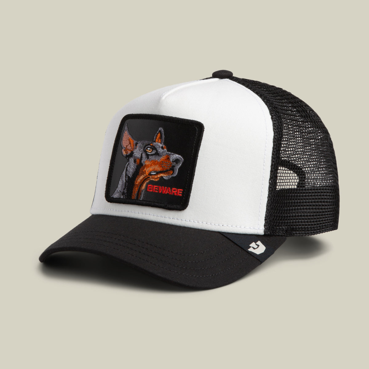 Introducing The Beware Dog by Goorin Bros.—a black and white classic trucker hat featuring a breathable mesh back and a bold front patch with a dog’s head and the word “BEWARE” in striking red text. Perfect for lovers of unique accessories, this eye-catching dog patch trucker adds an edgy twist to your everyday style.