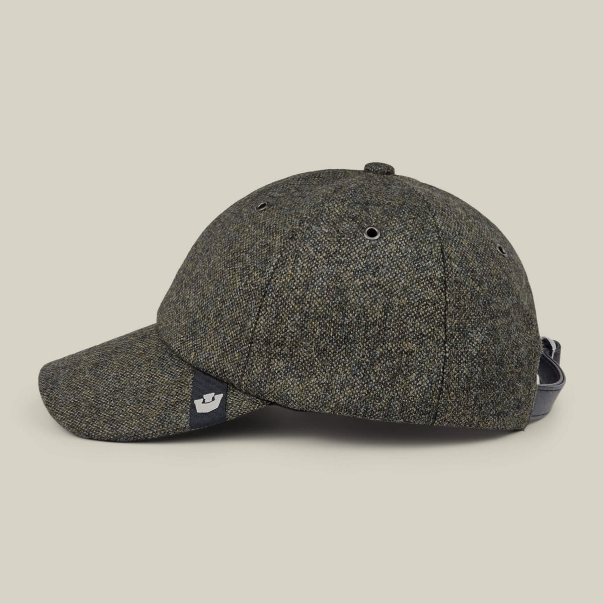 The Goorin Bros. Valmont is a grey tweed wool baseball cap, made in the USA, featuring a curved brim, a small black logo tag on the side, and an adjustable strap at the back, shown against a plain light background.
