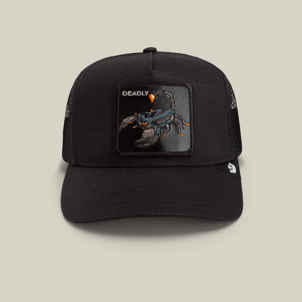 Goorin Bros. Deadly Scorpion black mesh trucker hat with a beige front patch featuring an embroidered scorpion and the word “DEADLY.”.