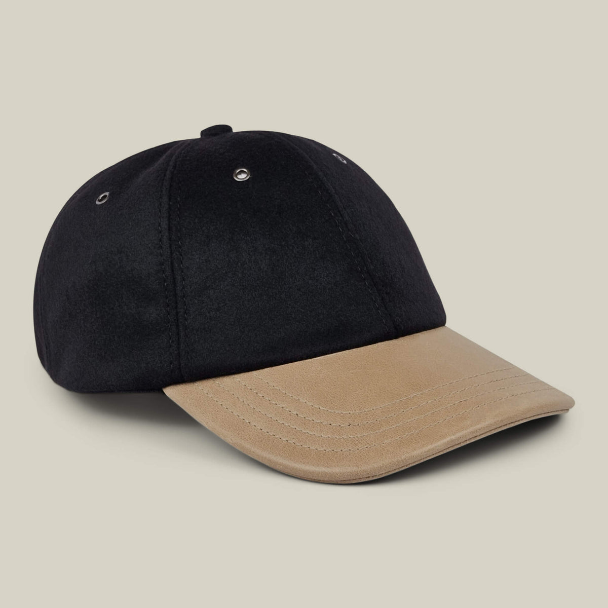 The Goorin Bros. Bixby cap, featuring a black crown and a tan brim, handmade in New Jersey, is displayed against a plain light beige background.