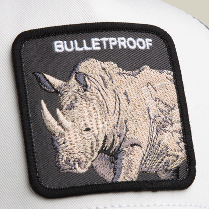 Close-up of the Goorin Bros. Bulletproof Trucker patch, featuring an embroidered rhinoceros and bold “BULLETPROOF” lettering, displayed on a light-colored surface—an eye-catching accent for your mesh back trucker hat.