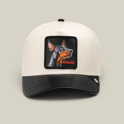 Introducing the Goorin Bros. Faux Leather Doberman trucker hat—a stylish white and black cap featuring an embroidered patch of a Doberman dog and the word “BEWARE” on the front, making it an ideal unique collectible for any dog lover.