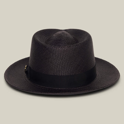 The Goorin Bros. "John Sr." is a dark brown toquilla teardrop fedora hat with a black ribbon band and 50 UPF sun protection, shown against a plain beige background.