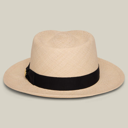 The Goorin Bros. John Sr. is a beige toquilla fedora hat with a wide brim and black ribbon band, offering 50 UPF sun protection, displayed on a neutral background.