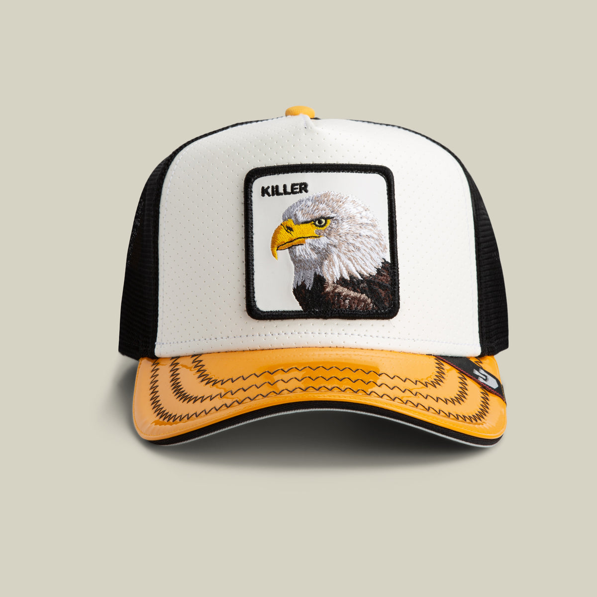 The Farm’s Concrete Killer trucker hat in white features a patch with an eagle head and “KILLER,” plus black mesh sides, a yellow/black brim. All sales final.