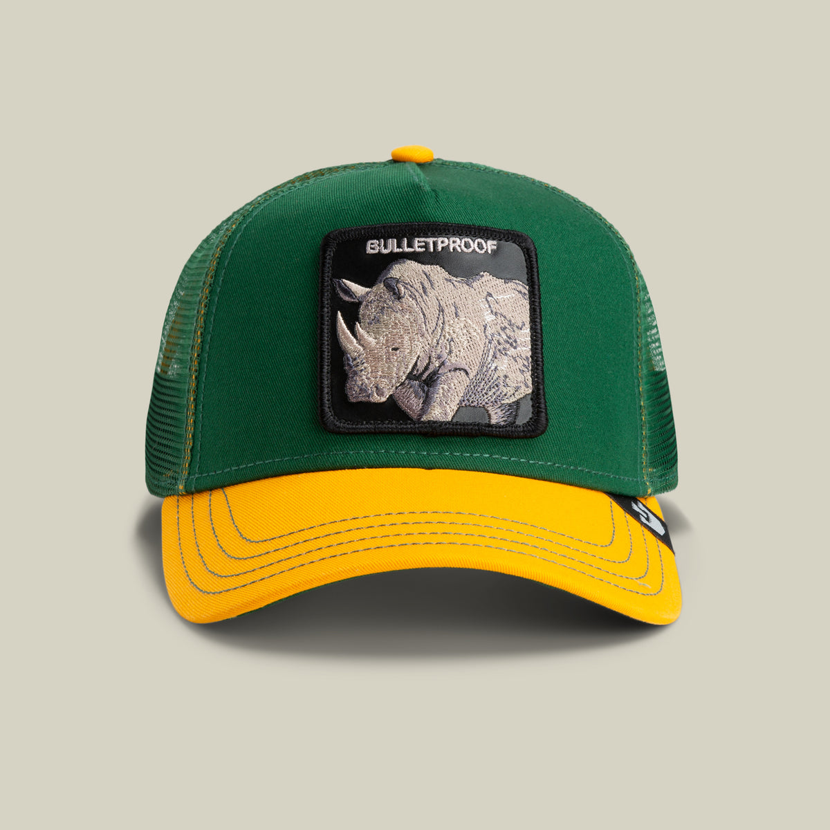 The Farm's "The Bulletproof Rhino" is a green trucker hat with a mesh back, featuring a rhino patch and "BULLETPROOF" on the front. All sales are final.