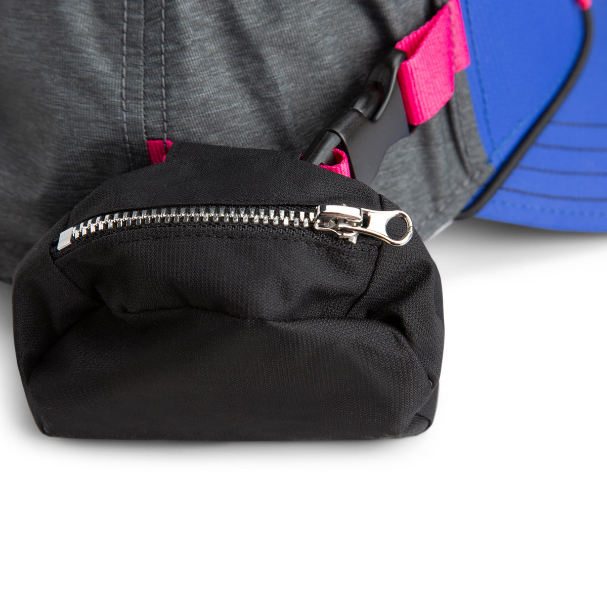 Close-up of The Farm’s Oversized Package—a black zippered pouch attached to a gray and blue fabric item with a pink strap and black plastic buckle—crafted from water-resistant materials for added durability.