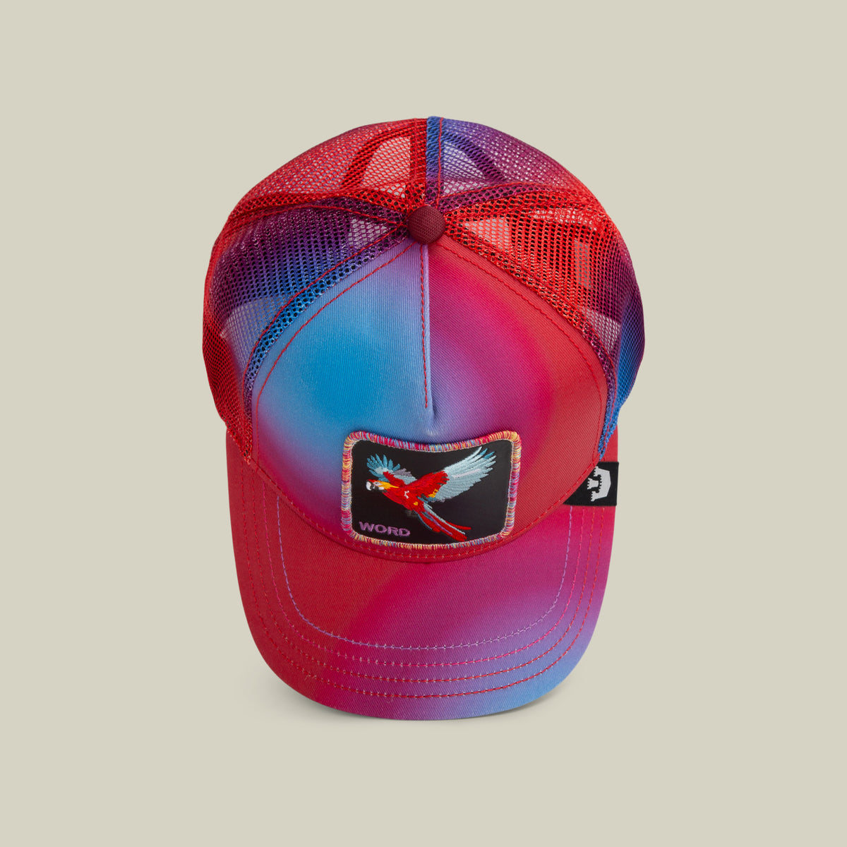 The Farm's "Bird is the Word" cap features a red and blue mesh design with a front patch of a bird and the word "WORD." All sales are final.