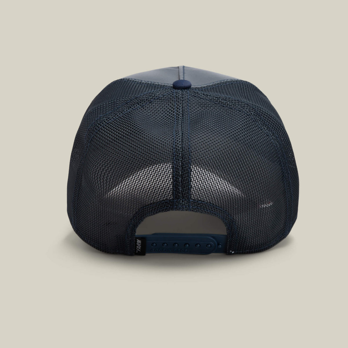 The Farm’s Shleather Wolf hat in navy blue mesh is shown from the back, highlighting its adjustable snap closure and a branded tag on the left—an on-trend statement piece for fashion-forward enthusiasts.