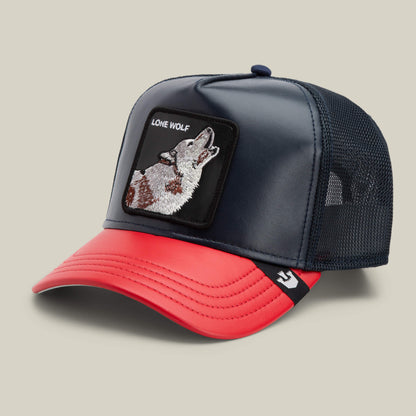 The Farm’s Shleather Wolf trucker hat features a navy mesh back, red brim, and an embroidered howling wolf patch with "LONE WOLF" text—perfect for bold, on-trend style.