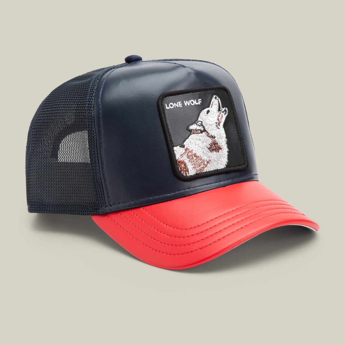 The Farm’s Shleather Wolf trucker hat features navy and red panels, a mesh back, and a front patch with a howling wolf and "LONE WOLF" text—a bold style choice for those who stand out.