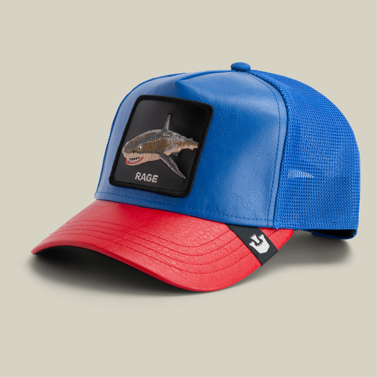 The Farm’s Deep Blue Fury is a blue and red trucker cap with a RAGE shark patch on the front and a black and white logo tag on the brim. All sales are final.