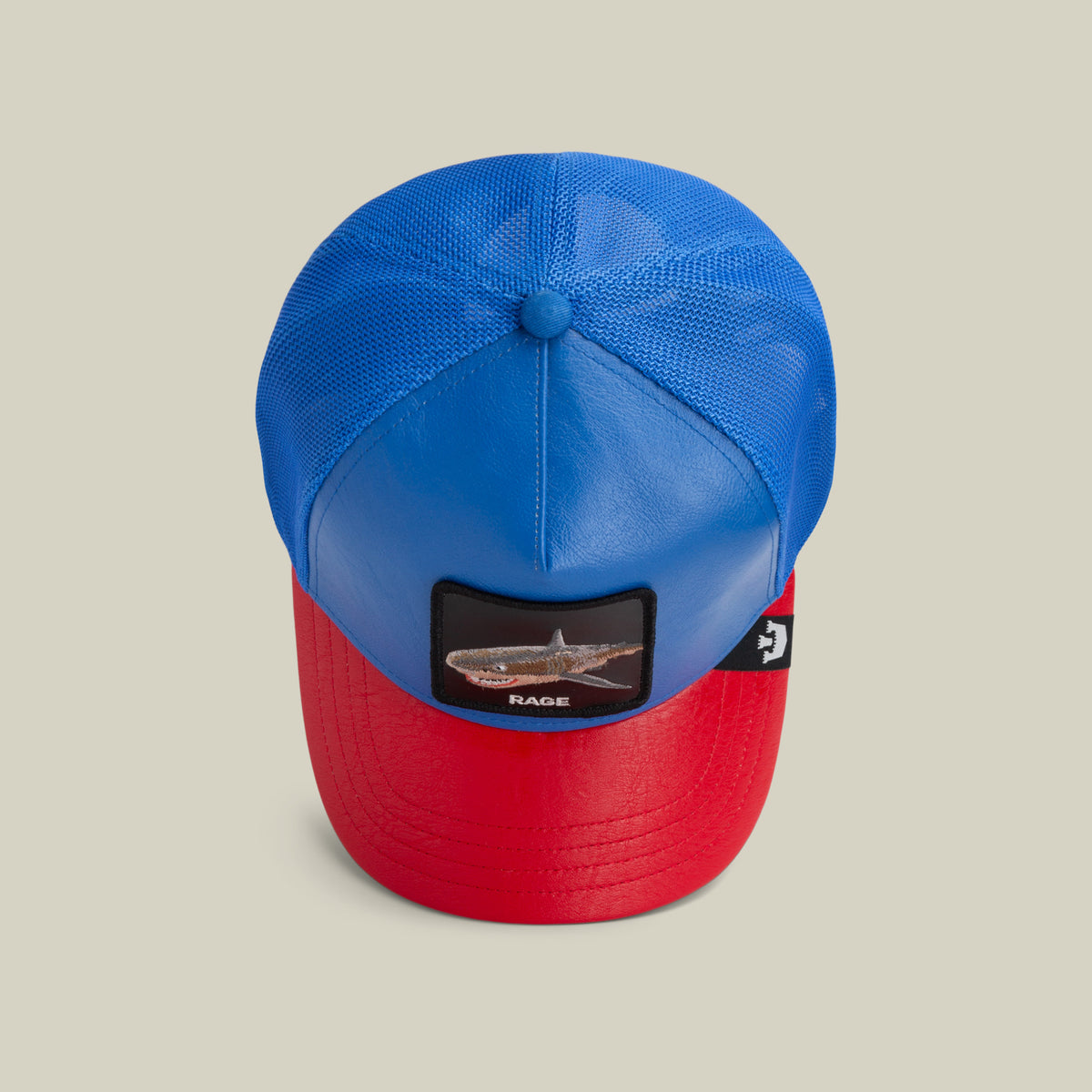 The Deep Blue Fury by The Farm is a blue and red baseball cap with a mesh back and a front patch showing a shark and "RAGE." All sales are final.