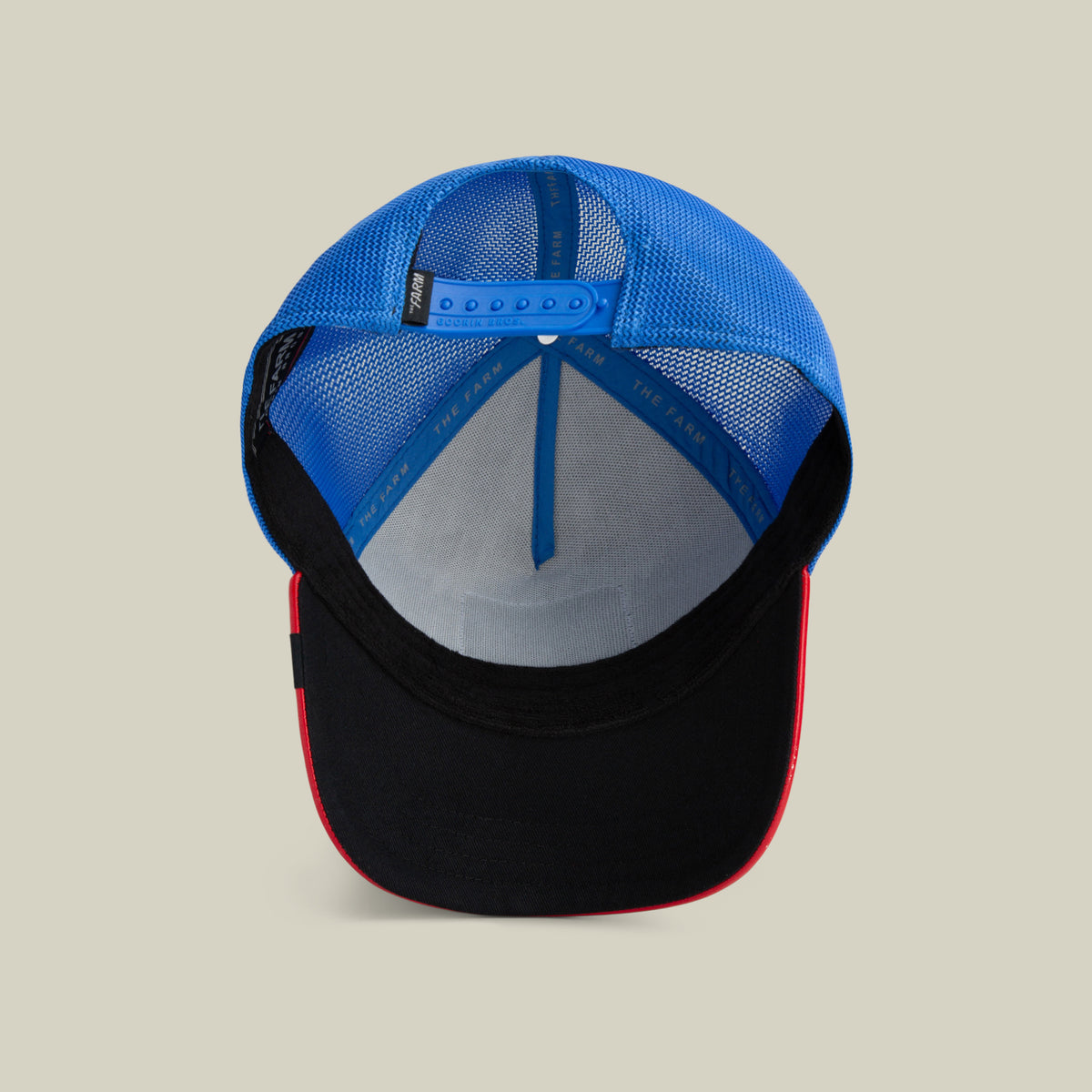 The Farm’s Deep Blue Fury cap features a blue mesh snapback, black visor, red edge trim, and adjustable strap. All sales are final.
