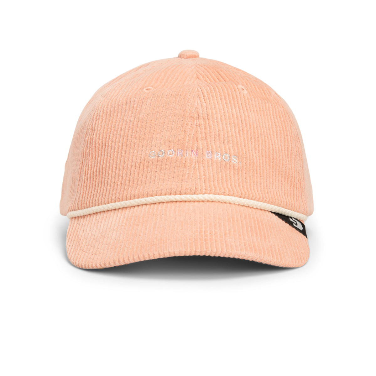 The Clubhouse by Goorin Bros. is a peach wide wale corduroy Papa Cap featuring signature Goorin Bros. embroidery on the front, a crisp white trim above the brim, and a subtle black side tag—an effortlessly refined accessory that brings quiet luxury to your style.