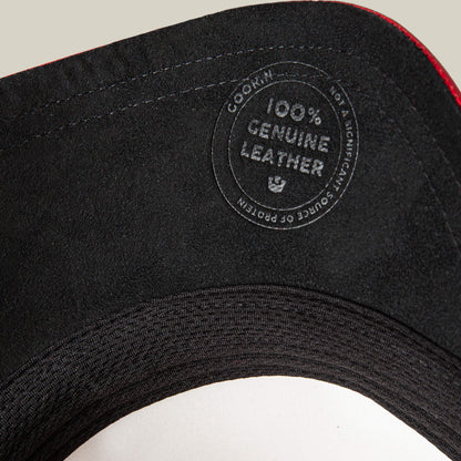Close-up of the LFG Raging Bull hat's black interior by Goorin Bros., showing a circular label that reads "100% Genuine high end leather." The leather’s origin is not featured as a key product detail.
