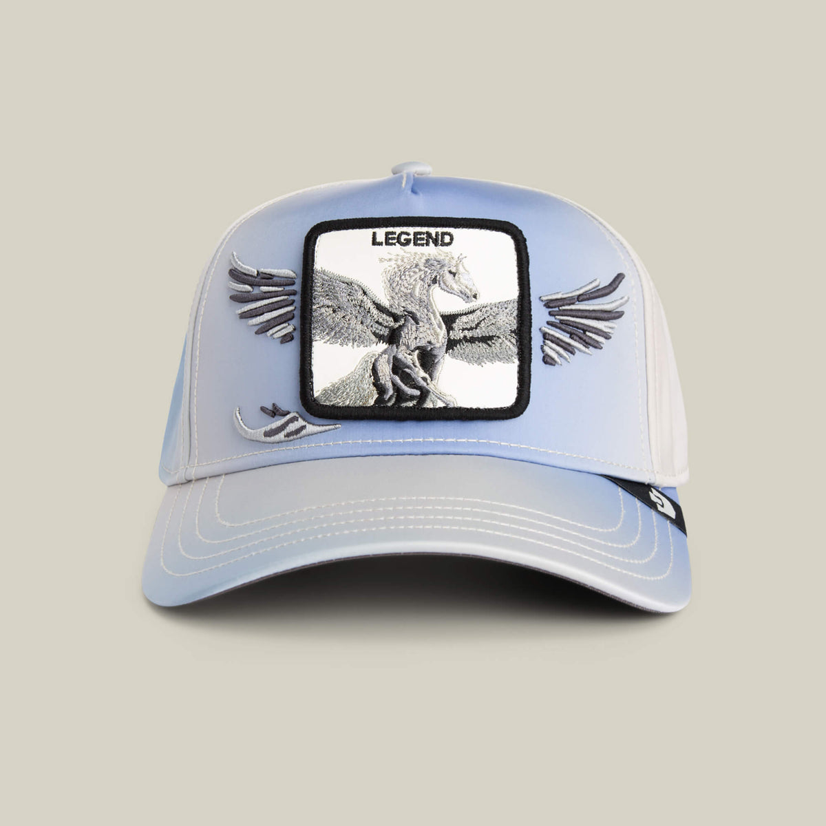 The Flare Up cap by Goorin Bros. features light blue and white panels, contrast stitching, a winged Pegasus "LEGEND" patch, and embroidered wings extending from the patch onto the cap.