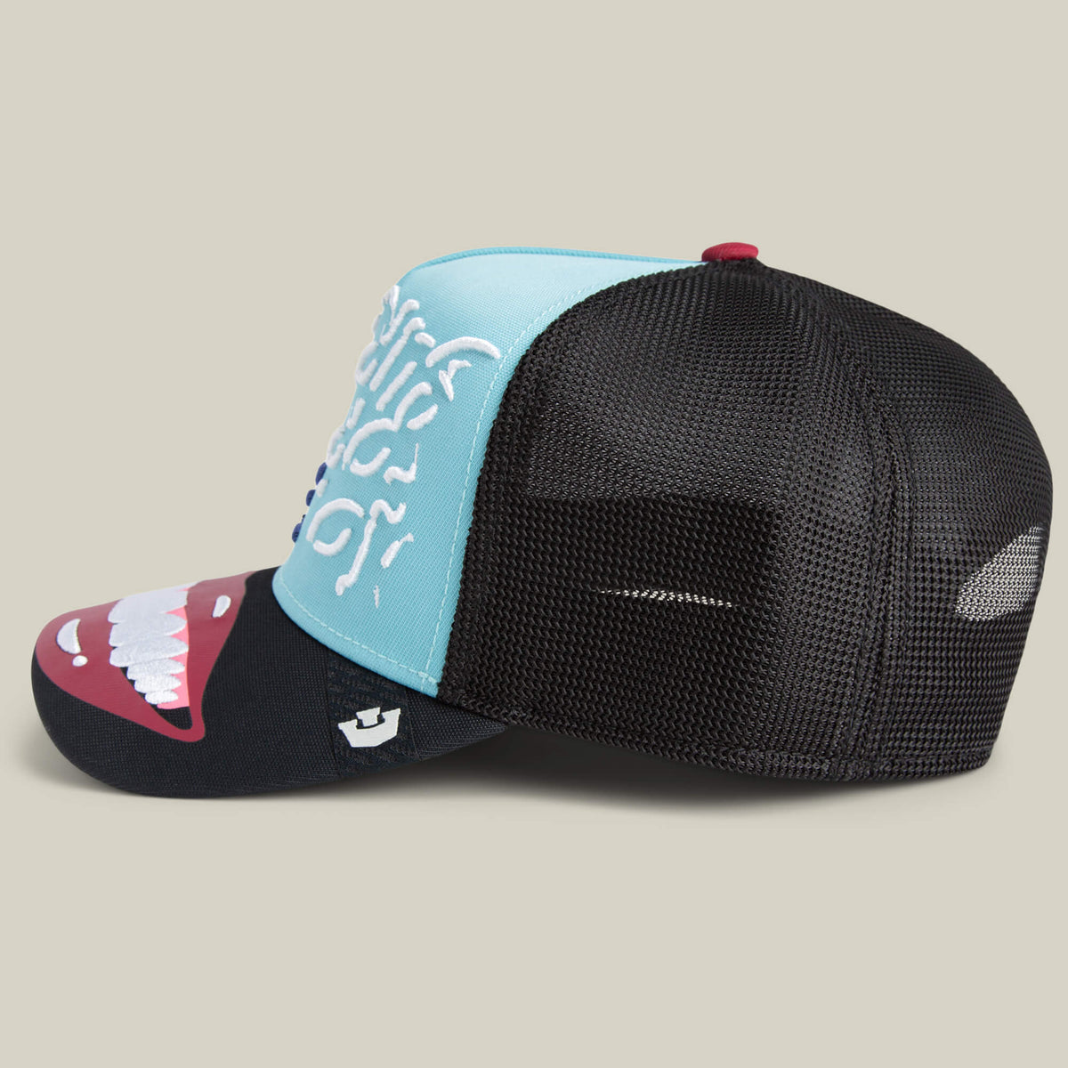 The Goorin Bros. Means Understood is a blue and black mesh trucker hat with a white teeth graphic in a red mouth on the front and white side designs. This playful hat adds style to any look. All sales are final.