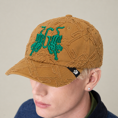 Wearing the Goorin Bros. "Future Baby Daddy" cap featuring green mirrored animals and a black tag, paired with a blue top and looking slightly down—serving main character energy.
