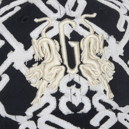 Close-up of the Goorin Bros. Future Baby Daddy cap: black fabric with all-over white geometric embroidery and two gold lions facing a stylized G in the center, showcasing the new branding.